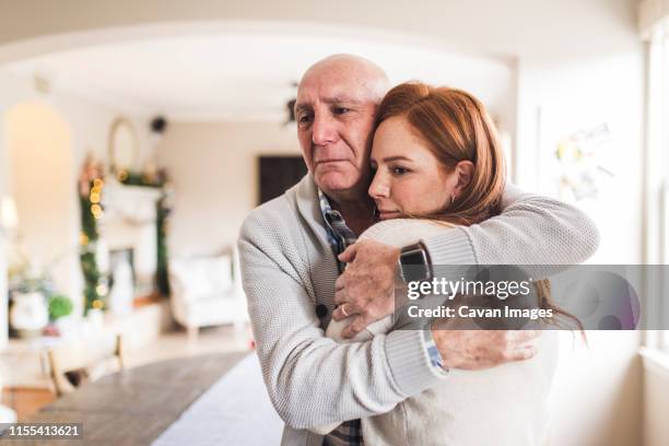 portrait of father hugging adult daughter with tears in his eyes - daughter crying stock pictures, royalty-free photos & images