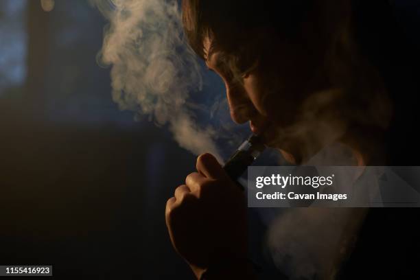 man smoking electronic cigarette - vape cigarette stock pictures, royalty-free photos & images