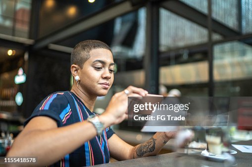 Junge Frau hinterlegt per Telefon im Café Junge Frau hinterlegt per Telefon im Café