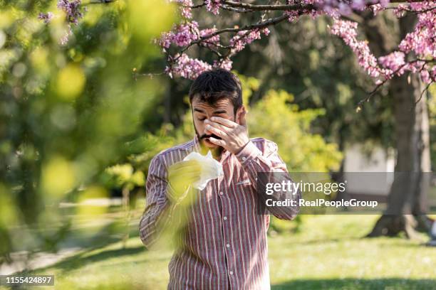 jeune homme à l’extérieur est d’avoir une allergie - pollen photos et images de collection
