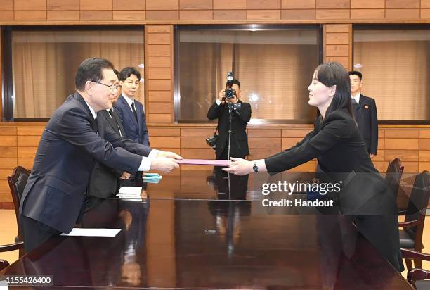 In this handout photo provided by the Ministry of Unification, Kim Yo-Jong , sister of North Korean leader Kim Jong Un, exchanges a document with...