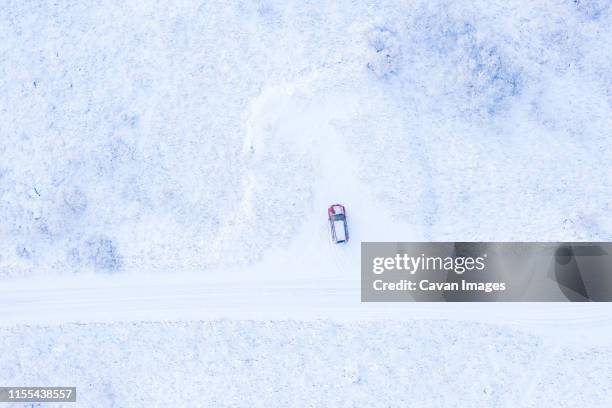 automobile parked between snow on field - winter storm stock pictures, royalty-free photos & images