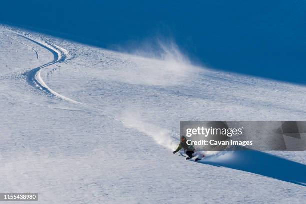 a man skis powder on a sunny bluebird day in copahue, argentina. - marca de esqui - fotografias e filmes do acervo