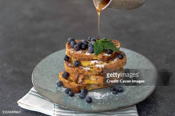 stack of french toast with blueberries and pouring maple syrup - pain perdu ストックフォトと画像