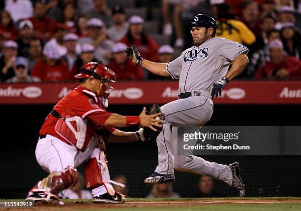 Johnny Damon#22 of the Tampa Bay Rays slides home as catcher Hank Conger of the Los Angeles Angels of Anaheim takes the throw before tagging Damon...