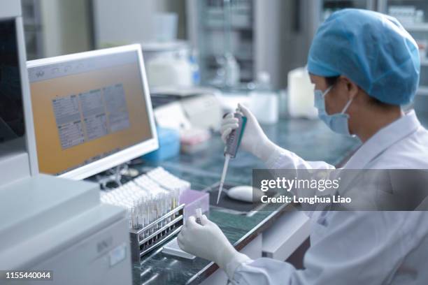 an asian female doctor operates in a medical laboratory - pharmaceutical industry stock pictures, royalty-free photos & images