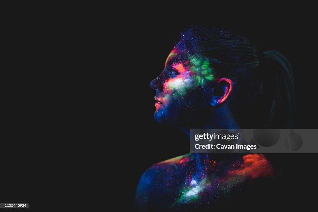Conceptual shot of light and shine fluorescent colors young girl's fac