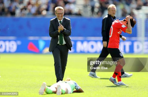 Hyeri Kim of Korea Republic looks dejected following her sides defeat as Thomas Dennerby, Head Coach of Nigeria congratulates Ngozi Ebere of Nigeria...