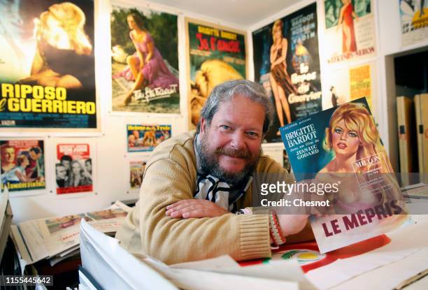 An expert on old posters, Frederic Lozada shows a poster of the movie "Le Mepris" with French actress Brigitte Bardot during the exhibition "The...