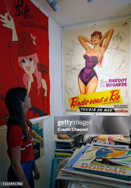 Woman looks at a poster of a movie with French actress Brigitte Bardot during the exhibition "The Bardot years 1952-1973" at Orsay Gallery on June...