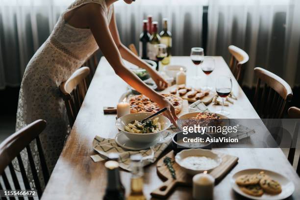 ung asiatisk kvinna som sätter bordet och serverar mat och vin redo för fest med vänner hemma - making friends bildbanksfoton och bilder
