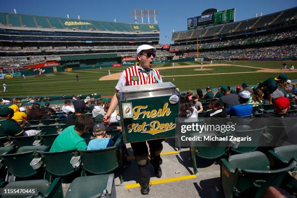 Hot dog vendor sells hot dogs in the stands during the game between the Oakland Athletics and the Seattle Mariners at the Oakland-Alameda County...