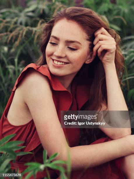 portrait of smiling redheaded woman outdoors - 髪に手をやる　女性 ストックフォトと画像