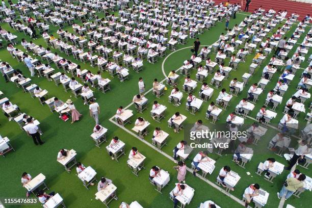 Aerial view of students from local middle schools and primary schools taking part in a Chinese calligraphy competition at a playground on June 12,...