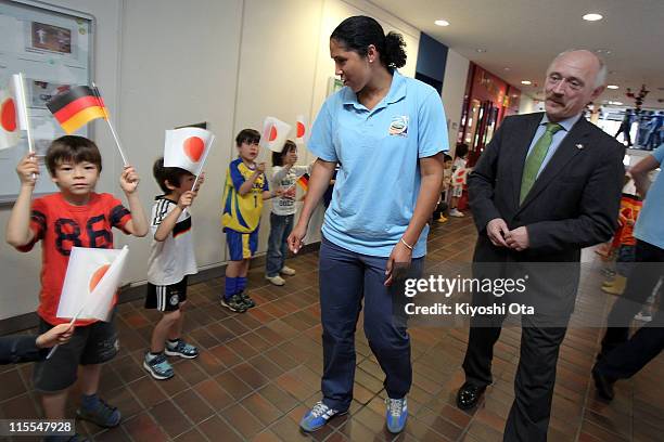 Steffi Jones , President of the Women's World Cup 2011 German Organizing Committee, is greeted by flag-waving children with Michael Szewczyk ,...