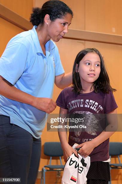 Steffi Jones, President of the Women's World Cup 2011 German Organizing Committee, gives a uniform to a student as she visits Deutsche Schule Tokyo...