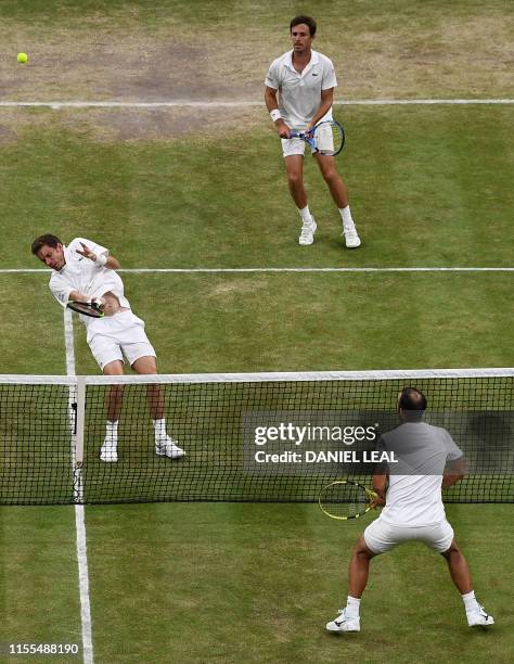 France's Nicolas Mahut reacts after he is hit by a ball as France's Edouard Roger-Vasselin looks on against Colombia's Juan Sebastian Cabal and...