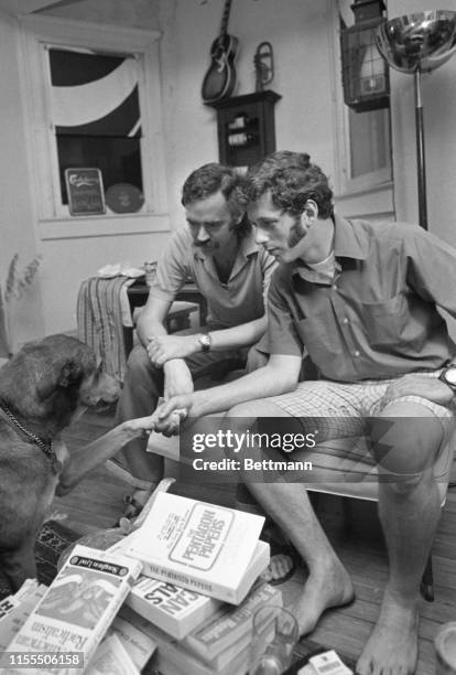 Barton Osborn and Michael Uhl, two former U.S. Military intelligence agents, play with Uhl's dog, Siegfried, at their home. Earlier, appearing before...
