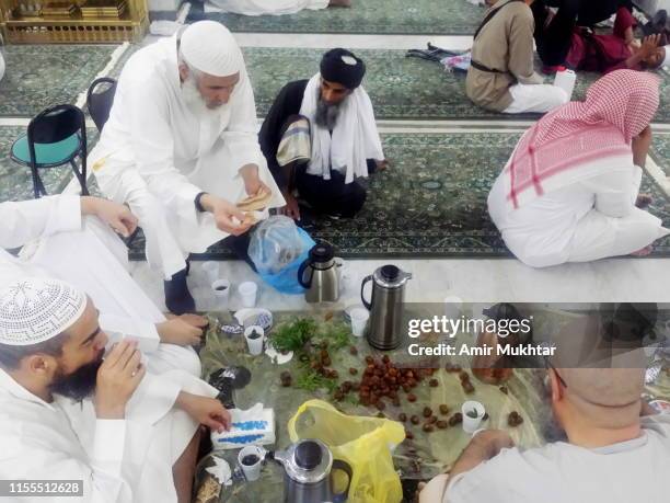 pilgrims taking iftar meal in mosque with dates, bread and tea - pilgrimage stock pictures, royalty-free photos & images