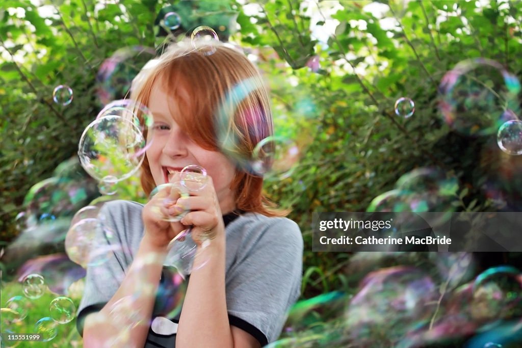 Girl laughing surronded by bubbles