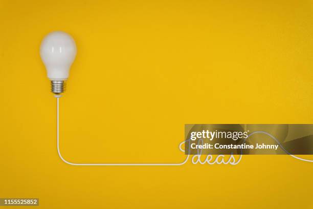 light bulb on yellow background. - johnny stark stock pictures, royalty-free photos & images