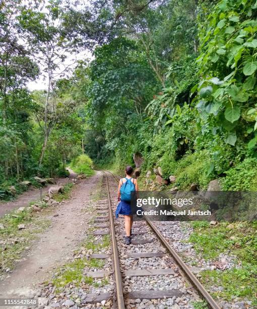 woman walking on the railroad to machu picchu. - berg huayna picchu stock-fotos und bilder