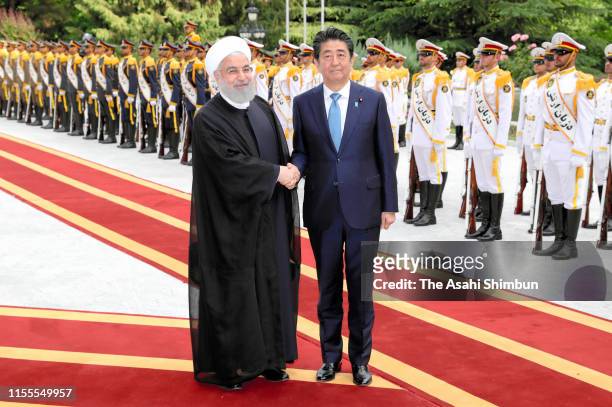 Japanese Prime Minister Shinzo Abe and Iranian President Hassan Rouhani shake hands during the welcome ceremony with at the Saadabad Palace on June...