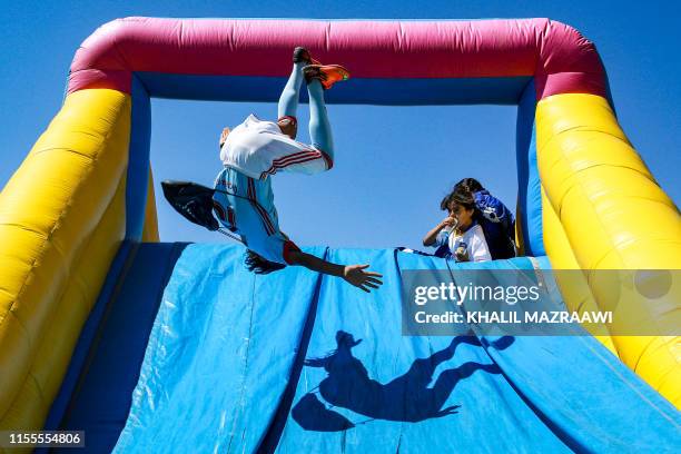 Children jump off an inflatable slide at the conclusion of the launch of LaLiga Zaatari Social Project, at the eponymous Syrian refugee camp in...