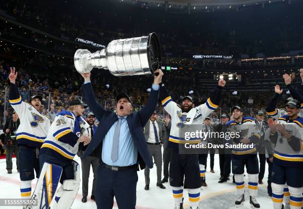 Head Coach Craig Berube of the St. Louis Blues hoists the Stanley Cup on the ice surrounded by his players after the 2019 NHL Stanley Cup Final at TD...