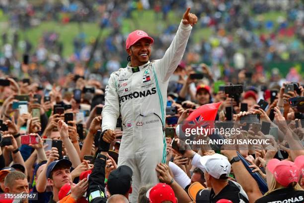 Mercedes' British driver Lewis Hamilton celebrates with supporters after victory in the British Formula One Grand Prix at the Silverstone motor...