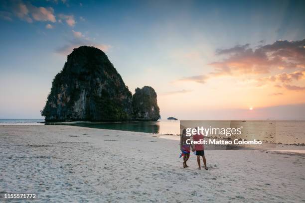 man and woman at phra nang beach at sunset, railay, thailand - krabi stock pictures, royalty-free photos & images