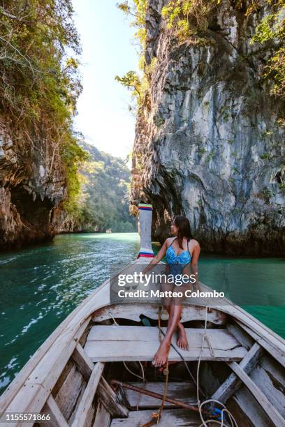 young woman on longtail boat prow, hong island, thailand - longtailboot stockfoto's en -beelden