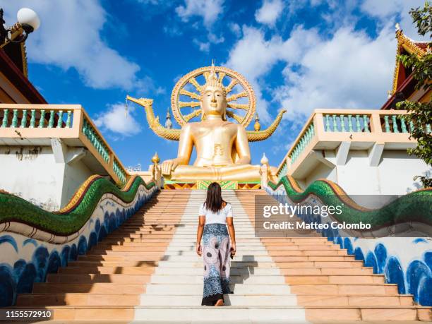 woman walking on the stairs leading to the big buddha, ko samui, thailand - grote boeddha stockfoto's en -beelden