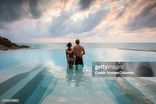 couple in an infinity pool at sunset, ko samui, thailand - couple swimwear stock pictures, royalty-free photos & images