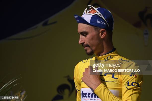 France's Julian Alaphilippe celebrates his overall leader's yellow jersey on the podium of the ninth stage of the 106th edition of the Tour de France...