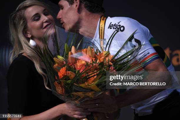 Stage winner South Africa's Daryl Impey kisses an hostess as he celebrates his victory on the podium of the ninth stage of the 106th edition of the...