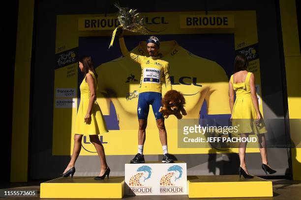 France's Julian Alaphilippe celebrates his overall leader's yellow jersey on the podium of the ninth stage of the 106th edition of the Tour de France...