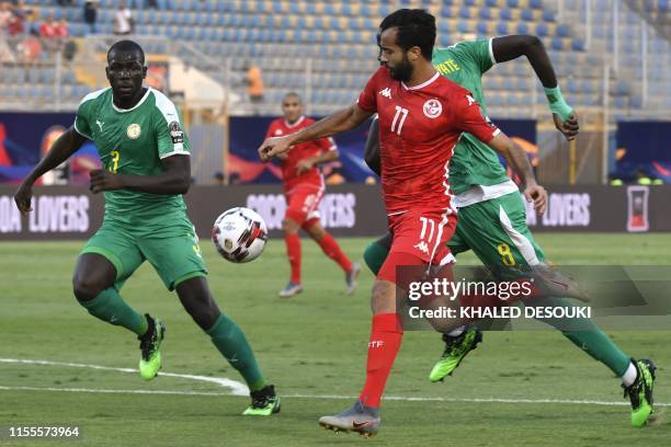 Tunisia's forward Taha Yassine Khenissi fights for the ball with Senegal's defender Kalidou Koulibaly and Senegal's defender Cheikhou Kouyate during...