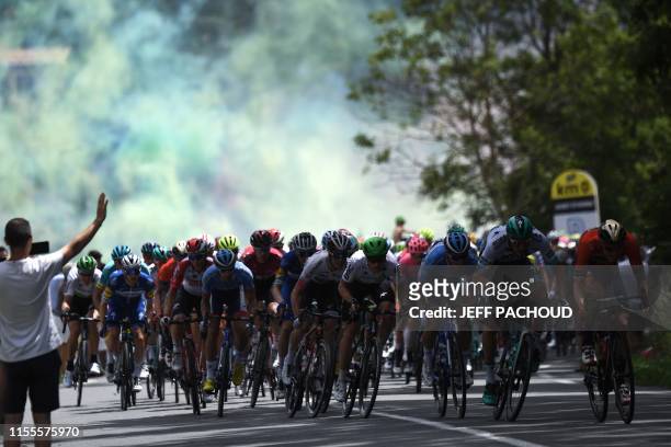 Fireworks explode in background as riders take the start of the ninth stage of the 106th edition of the Tour de France cycling race between...