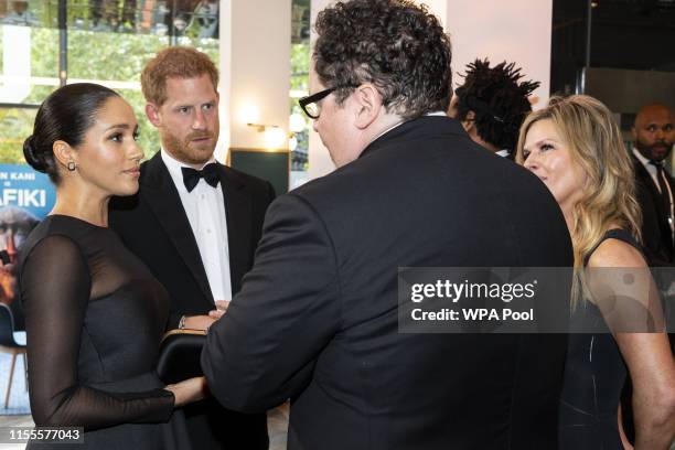 Prince Harry, Duke of Sussex and Meghan, Duchess of Sussex chat with US film director Jon Favreau at the European Premiere of Disney's "The Lion...