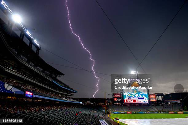 Lightning strikes behind Coors Field during a rain delay before a baseball game between the Cincinnati Reds and the Colorado Rockies on July 13, 2019...