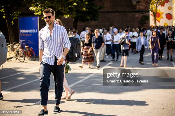 Johannes Huebl, wearing a white and grey striped shirt, blue pants, and dark loafers, is seen during Pitti Immagine Uomo 96 on June 12, 2019 in...