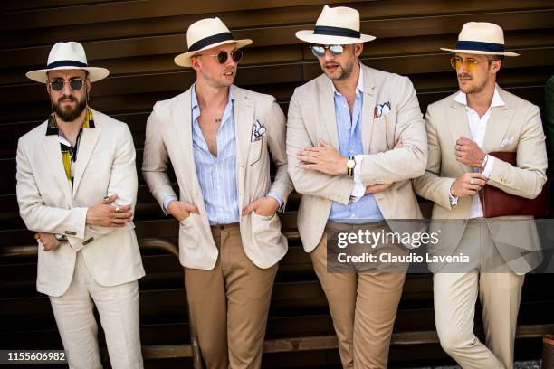 Gentlemen, wearing light color suits and straw hats, are seen during Pitti Immagine Uomo 96 on June 12, 2019 in Florence, Italy.