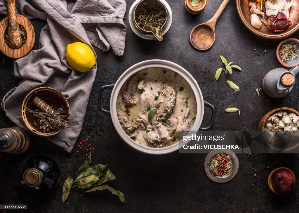 Creamy wildfowl ragout or stew in pot on kitchen table with ingredients