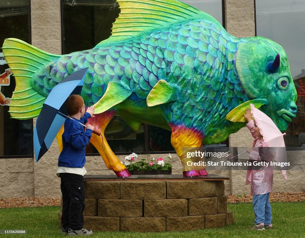 Joey McLeister/Star Tribune Buffalo,Mn.,Sat.,May 29, 2004--(Left to right) Six-year-old Chase and four-year-old Lexis Schmidt of Otsego pat the "Buffalo Fish" outside Buffalo Cinema. Artists Meredith Johanson and Diane Paulu teamed up to paint Buffalo Fi