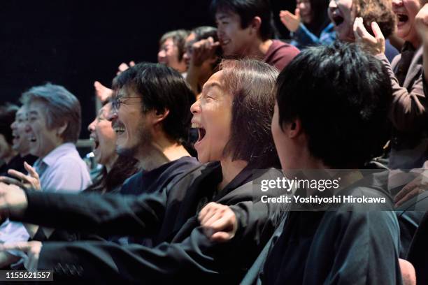 japanese people laughing watching a comedy at the theater - asian watching movie stock pictures, royalty-free photos & images