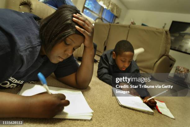 Brooklyn Center, MN 2/2004--Chantelle Powell 17 yr. Old 11th grader at Champlain Park High School sudies at home with her younger Brother 8 yr. Old...