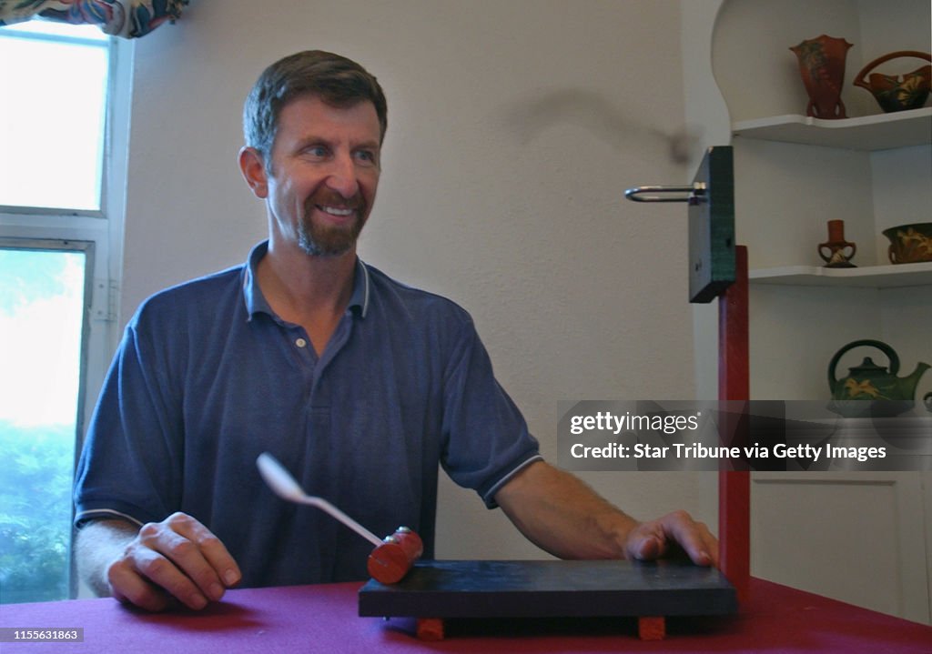 Joey McLeister/Star Tribune Minneapolis,Mn.,Weds.,Sept. 22, 2004--Bill Gurstelle sinks a Brazil nut in one of the catapults he made with a plastic spoon launcher.  Gurstelle is an engineer, speaker and an author of books about catapults and "backyard ball