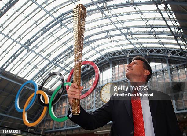 Chair and former Olympian Lord Sebastian Coe holds a prototype design of the new golden Olympic Torch during its unveiling at St Pancras Station on...