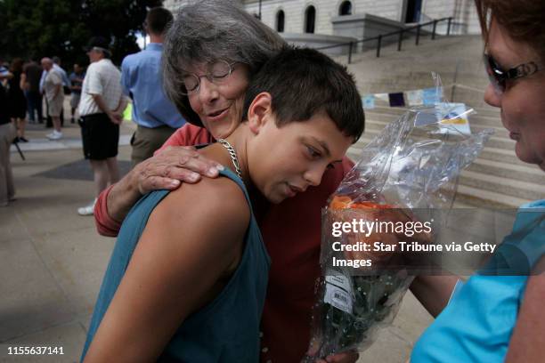Jerry Holt/Star Tribune 8/21/2005--------State Senator Becky Lourey left received a hug and a dozen rose from 13-year-old Amir Rose of Plymouth as...